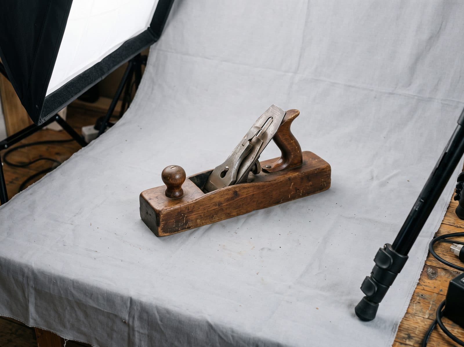 Studioaufbau mit Softbox und grauem Hintergrundtuch, darauf ein hölzerner Handhobel